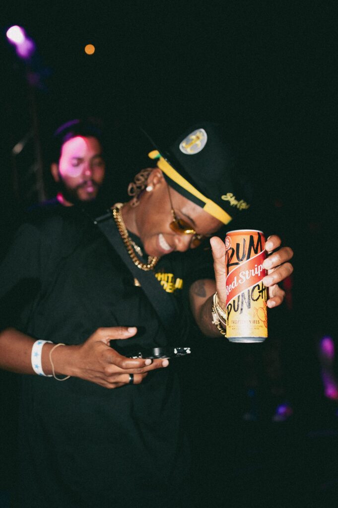 Person partying at club holding up a Red Stripe canned drink